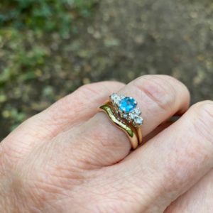 Blue topaz and diamond engagement ring with fitted yellow gold wedding ring