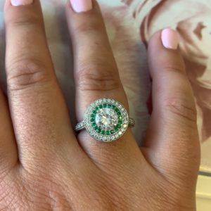 Round brilliant diamond with emerald and diamond double halo